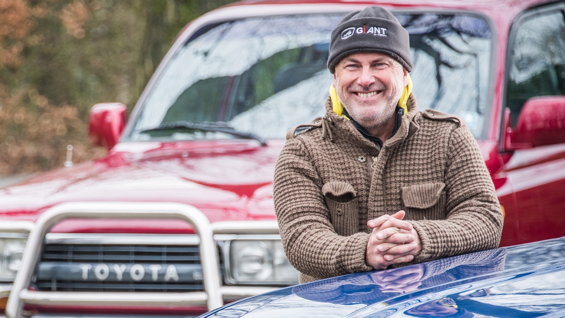 Dick-Admiraal-bij-zijn-Toyota-Hilux-Land-Cruiser-HDJ80-exterieur-blauw-rood-close-up.jpg